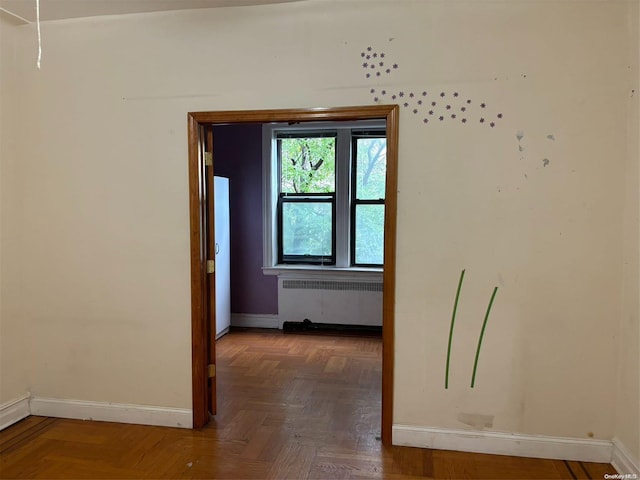 interior space with dark parquet flooring and radiator