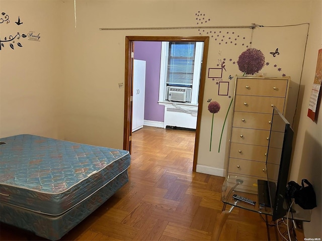 bedroom featuring cooling unit, radiator heating unit, and parquet floors