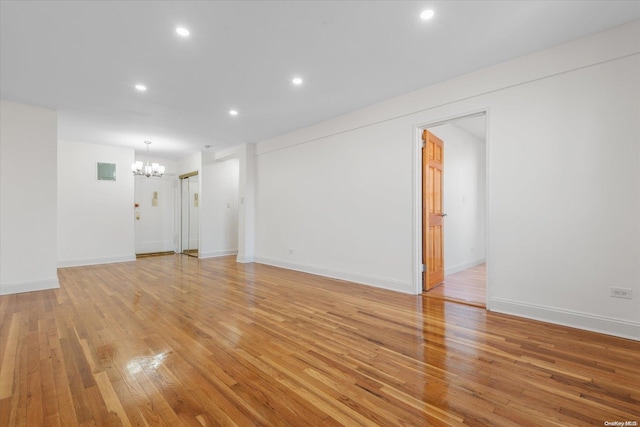 unfurnished living room featuring light hardwood / wood-style floors and a chandelier