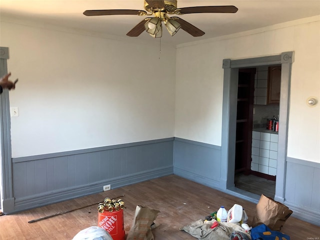 interior space featuring ceiling fan, hardwood / wood-style floors, and crown molding