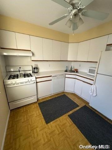 kitchen featuring white appliances, ceiling fan, sink, white cabinets, and light parquet flooring