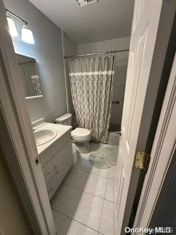 bathroom featuring tile patterned floors, vanity, and toilet