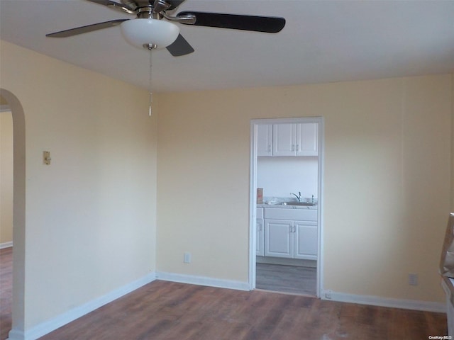 unfurnished room with wood-type flooring, ceiling fan, and sink