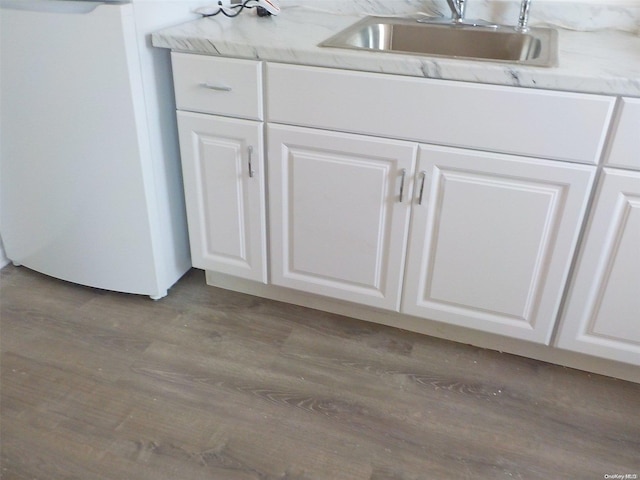 details with wood-type flooring, white cabinetry, and sink