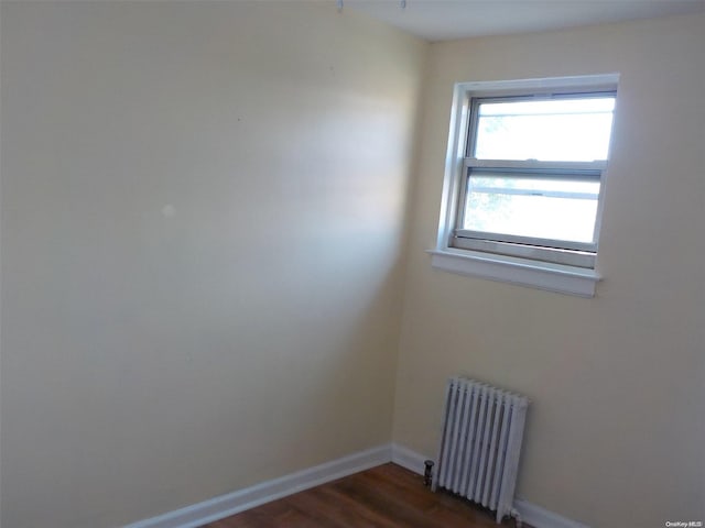 unfurnished room featuring dark hardwood / wood-style floors and radiator