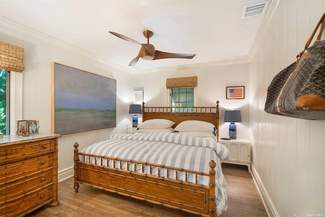 bedroom with dark hardwood / wood-style flooring, ceiling fan, and ornamental molding