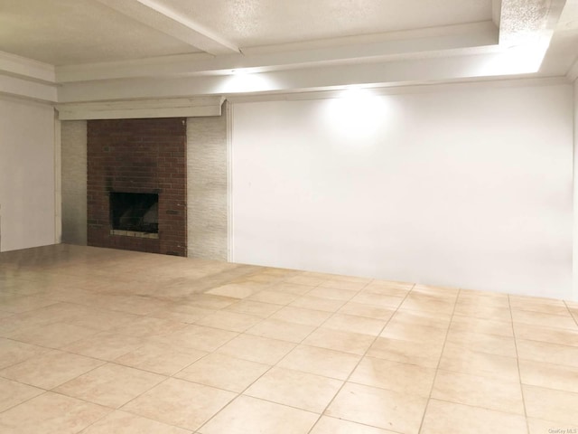 basement featuring a brick fireplace, light tile patterned floors, and a textured ceiling