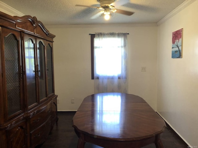 dining room with ceiling fan, crown molding, dark wood-type flooring, and a textured ceiling