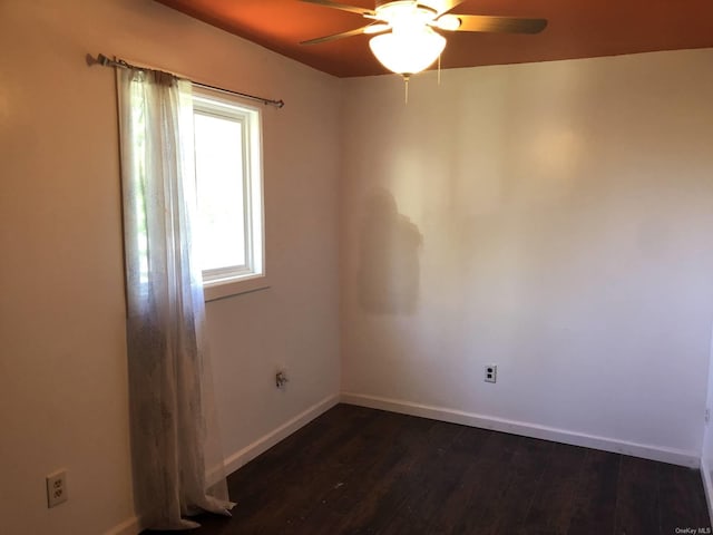 spare room with ceiling fan and dark hardwood / wood-style flooring