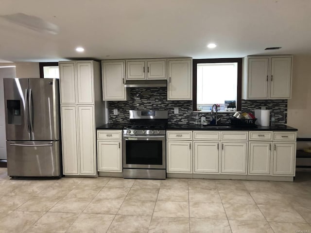 kitchen featuring sink, light tile patterned floors, stainless steel appliances, and cream cabinetry