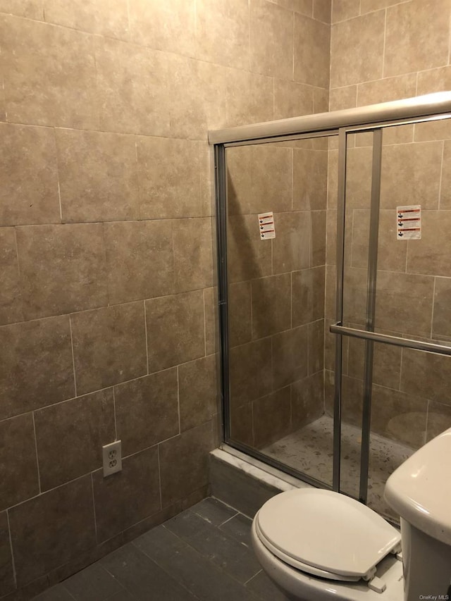 bathroom with an enclosed shower and toilet