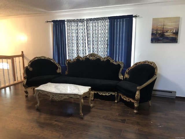 sitting room with a textured ceiling, baseboard heating, and wood finished floors