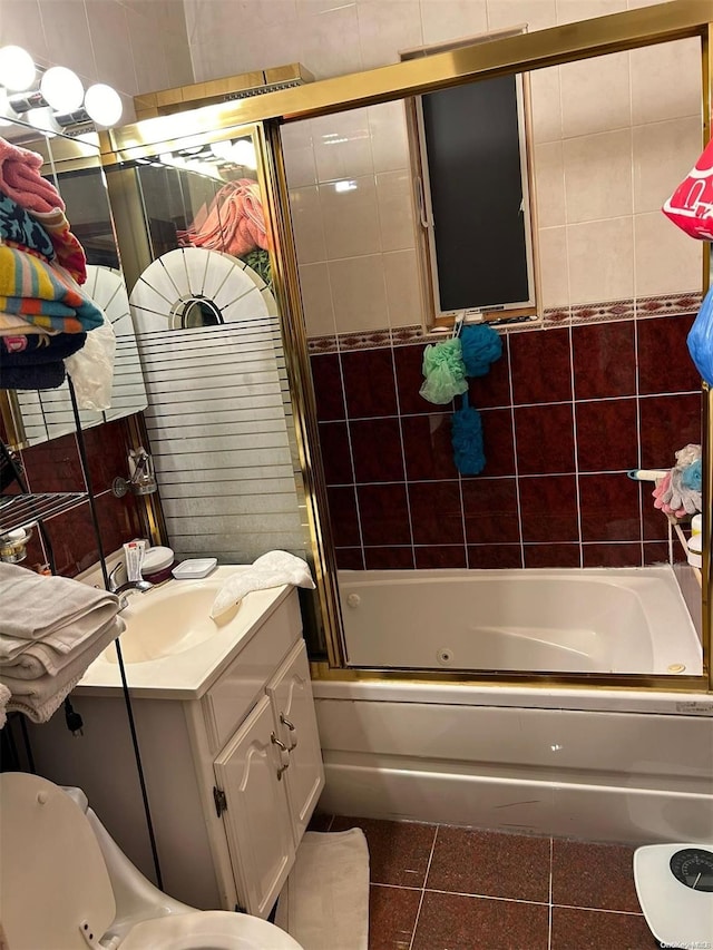 bathroom featuring combined bath / shower with glass door, vanity, and tile walls