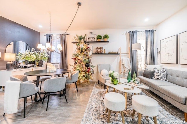 living room featuring light hardwood / wood-style floors, a healthy amount of sunlight, and an inviting chandelier