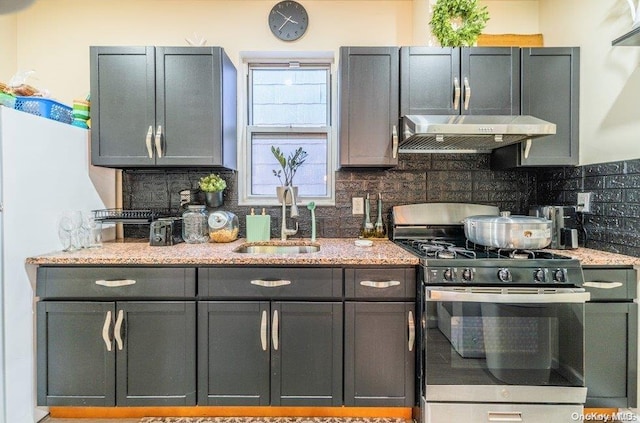 kitchen featuring light stone countertops, gas stove, tasteful backsplash, and exhaust hood