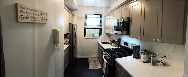 kitchen featuring gray cabinetry, backsplash, and stainless steel appliances