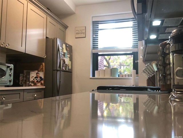 kitchen with stainless steel fridge and gray cabinetry