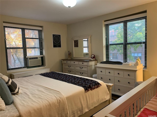 bedroom with cooling unit and hardwood / wood-style flooring