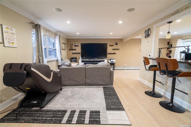 living room with a wealth of natural light, light hardwood / wood-style flooring, and ornamental molding