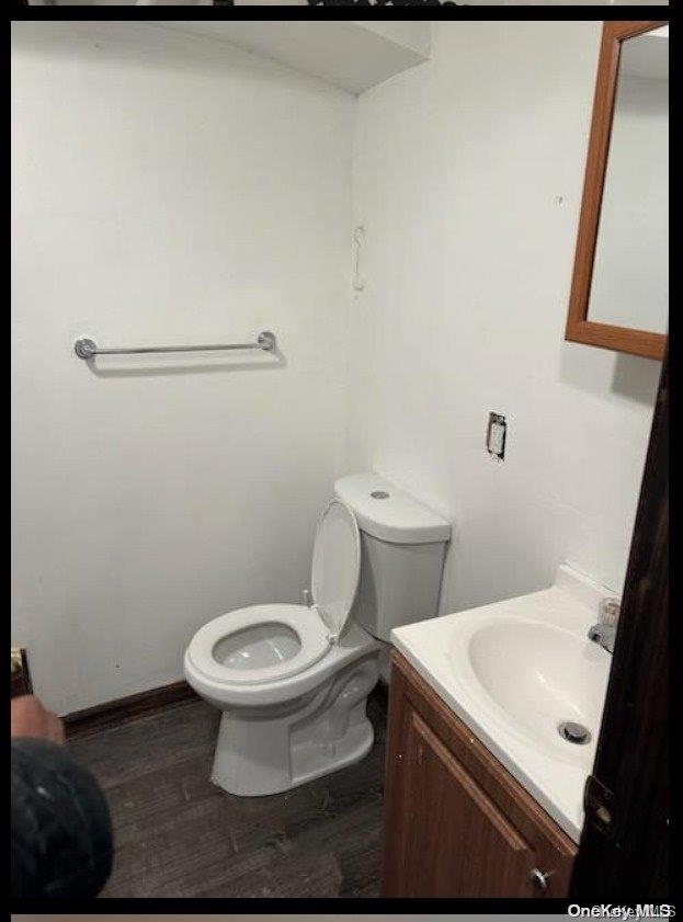 bathroom with hardwood / wood-style floors, vanity, and toilet