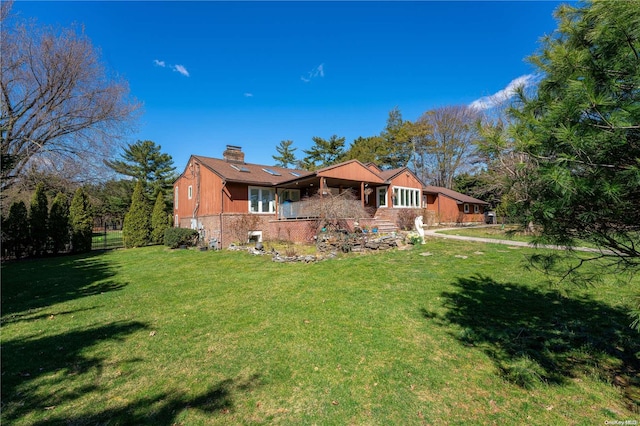 rear view of property featuring a lawn