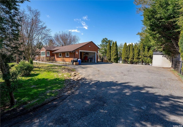 ranch-style home with a garage and a front lawn