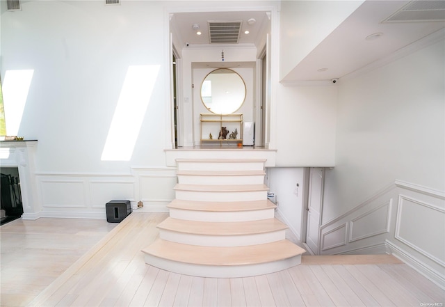 stairs with hardwood / wood-style floors and a skylight