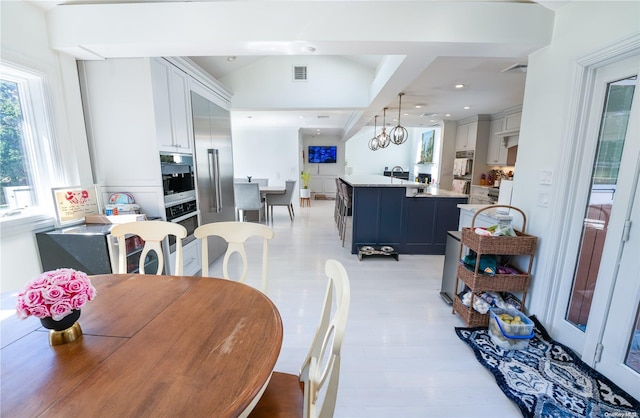 dining space featuring vaulted ceiling and a notable chandelier