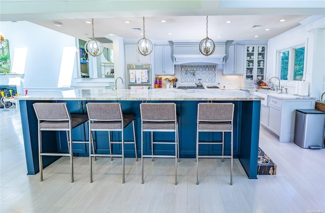 kitchen with a breakfast bar, decorative light fixtures, a spacious island, and stainless steel oven