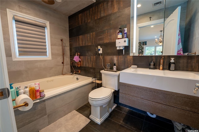 bathroom with tile patterned flooring, tile walls, and an inviting chandelier