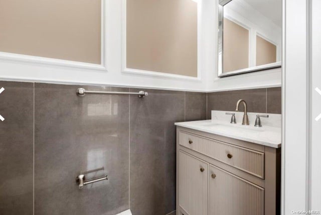 bathroom with vanity and tile walls