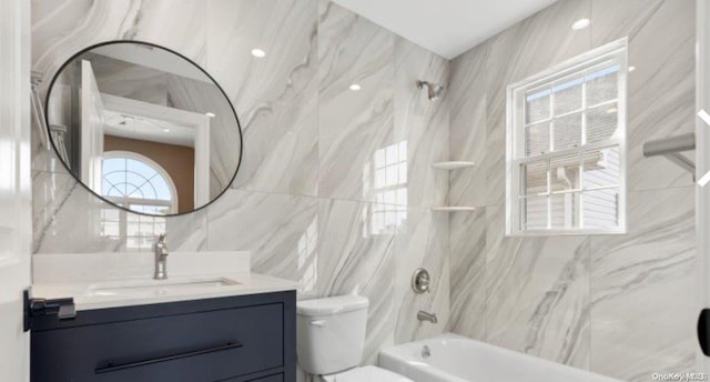 full bathroom featuring vanity, tiled shower / bath combo, tile walls, and toilet