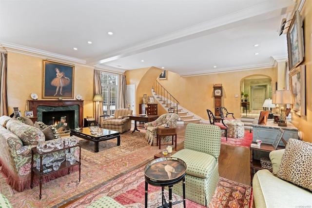 living room with crown molding, hardwood / wood-style floors, and a premium fireplace