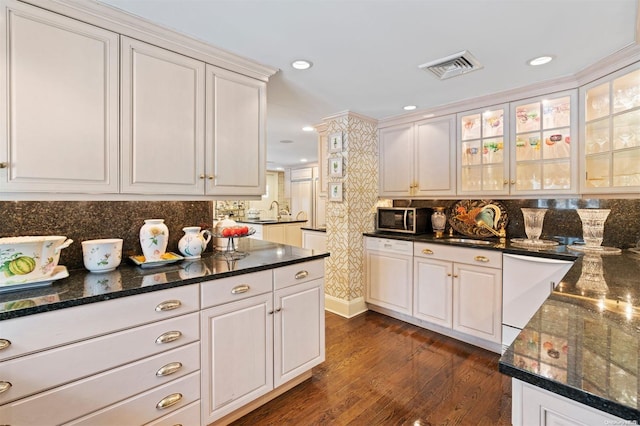 kitchen featuring white cabinets, dark hardwood / wood-style flooring, and tasteful backsplash