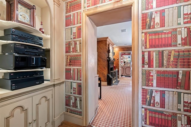 hallway with wood walls and ornamental molding