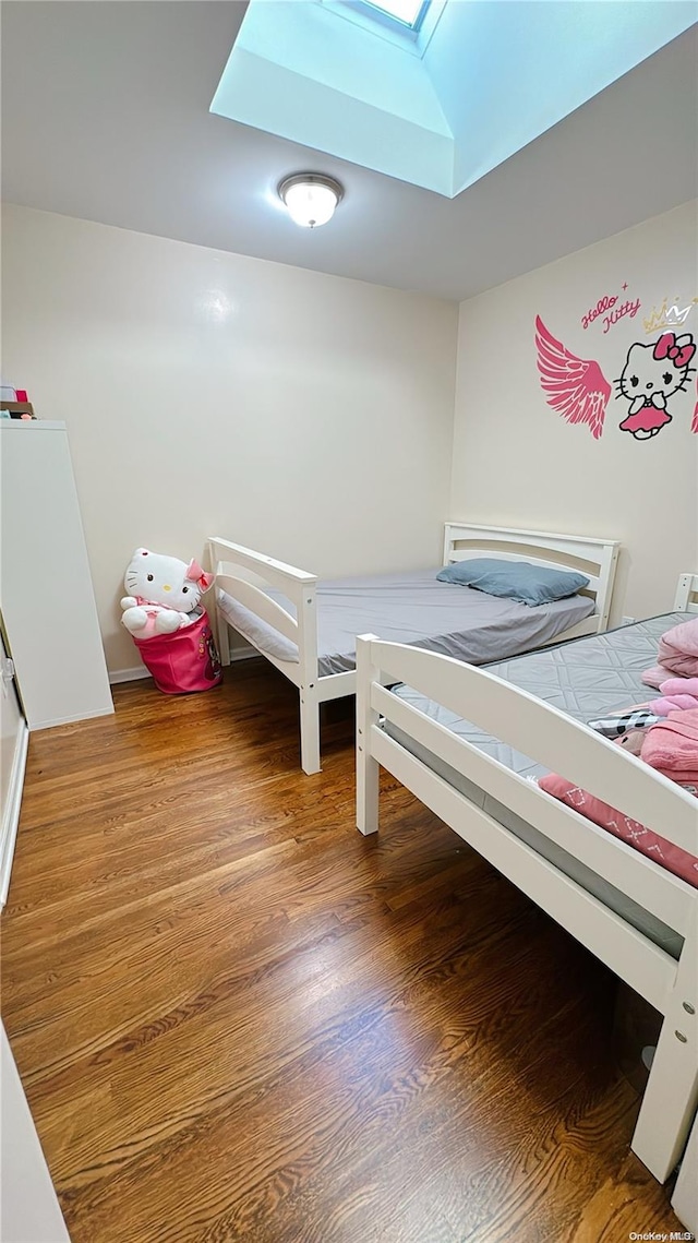 bedroom with a skylight and wood-type flooring