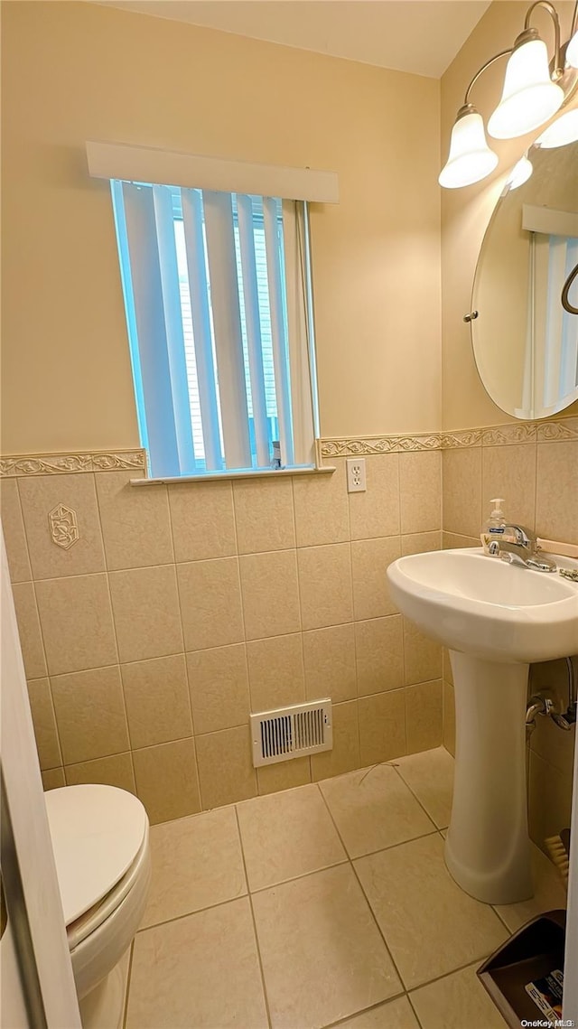 bathroom with tile patterned floors, tile walls, and toilet