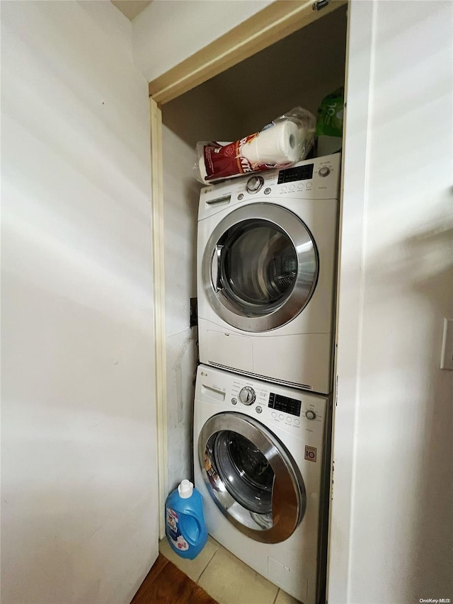 laundry area featuring tile patterned floors and stacked washer and dryer