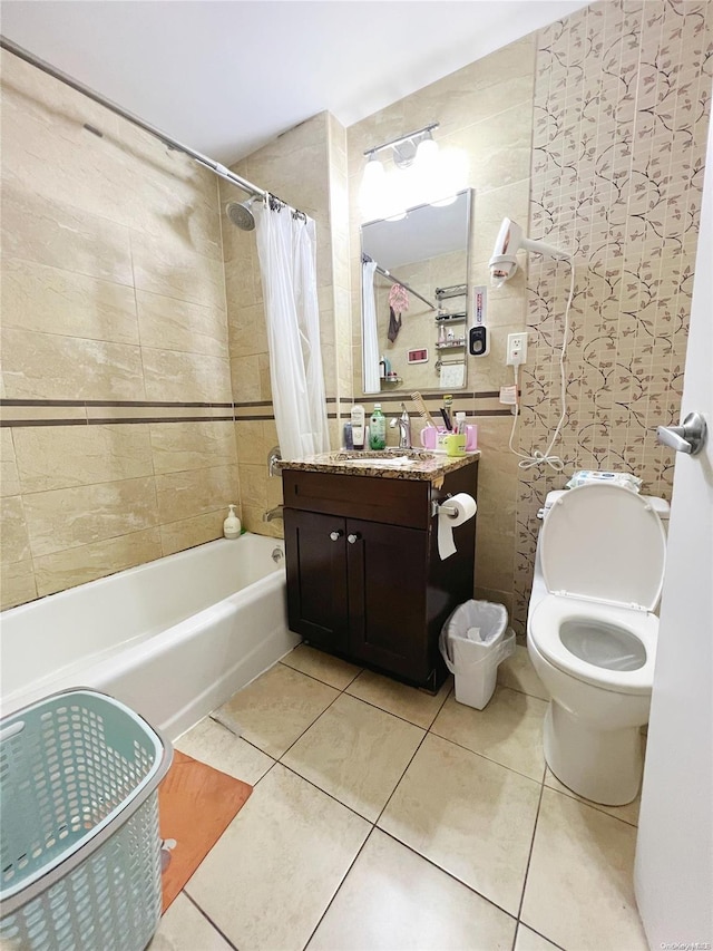 full bathroom featuring shower / bathtub combination with curtain, tile patterned flooring, toilet, vanity, and tile walls