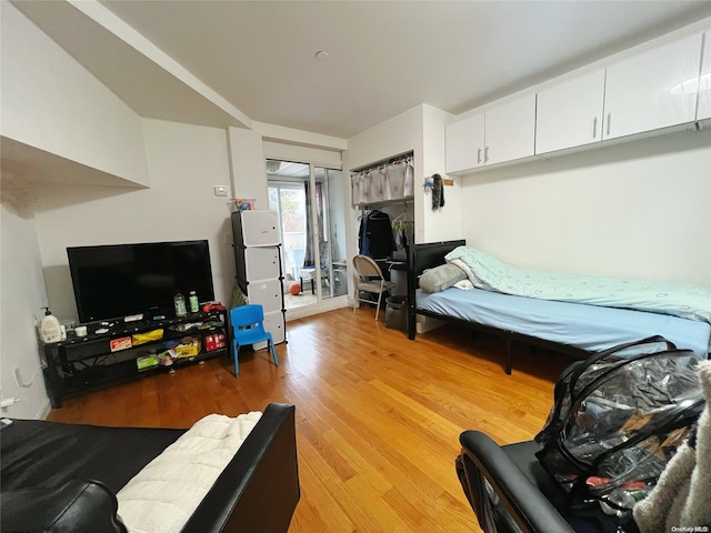 bedroom featuring access to outside, a closet, and light hardwood / wood-style floors