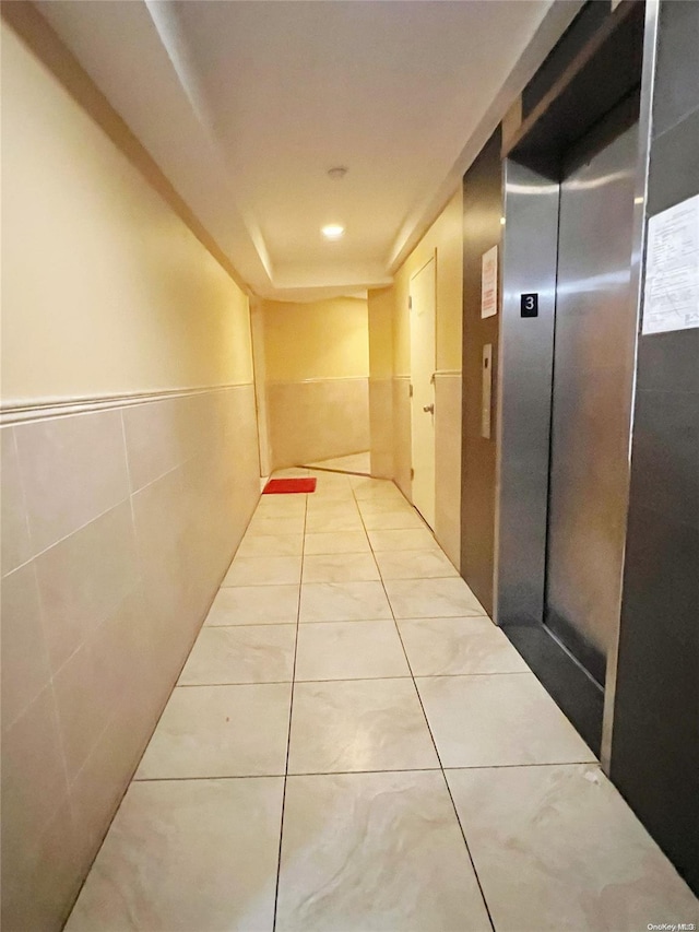 hallway with light tile patterned floors and elevator