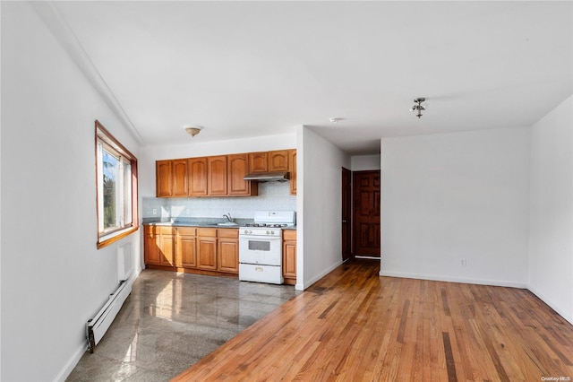 kitchen with white gas range oven, a baseboard radiator, hardwood / wood-style flooring, and backsplash