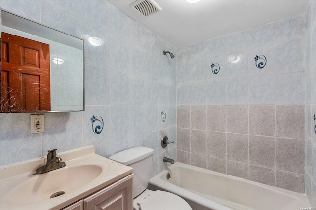 full bathroom with vanity, toilet, tile walls, and tiled shower / bath