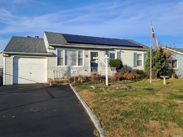 view of front facade featuring solar panels, a garage, and a front lawn