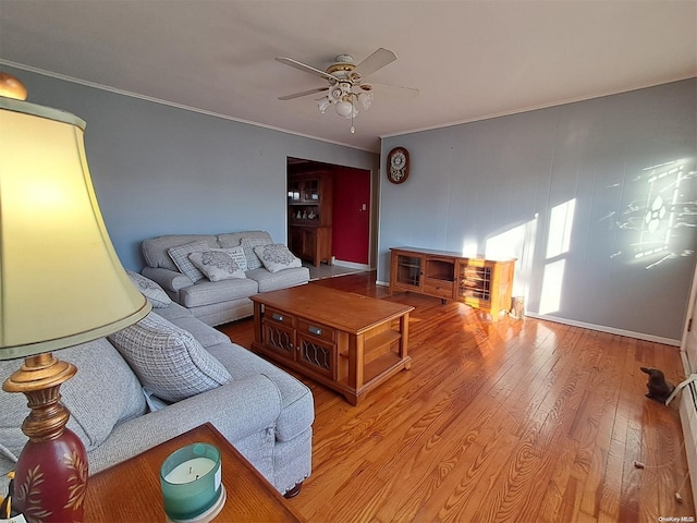 living room featuring ceiling fan, hardwood / wood-style floors, and ornamental molding