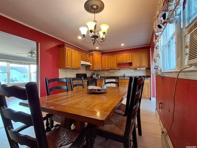 dining area featuring ceiling fan with notable chandelier, light tile patterned flooring, and crown molding