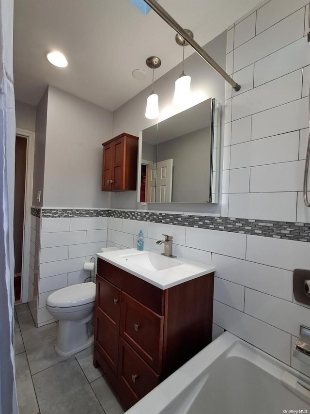 bathroom featuring tile patterned flooring, vanity, toilet, and tile walls