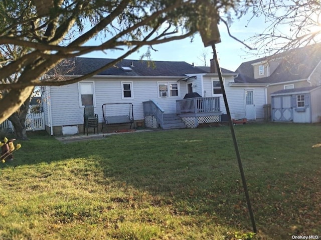 back of house featuring a lawn and a deck