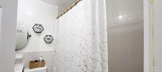 607 Ashford St, Brooklyn, NY 11207 - full bathroom featuring tile walls, a shower with shower curtain, and toilet