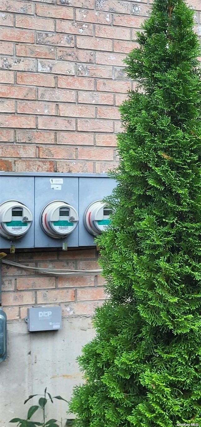 607 Ashford St, Brooklyn, NY 11207 - exterior view of electric meter, brick siding, and a wood stove